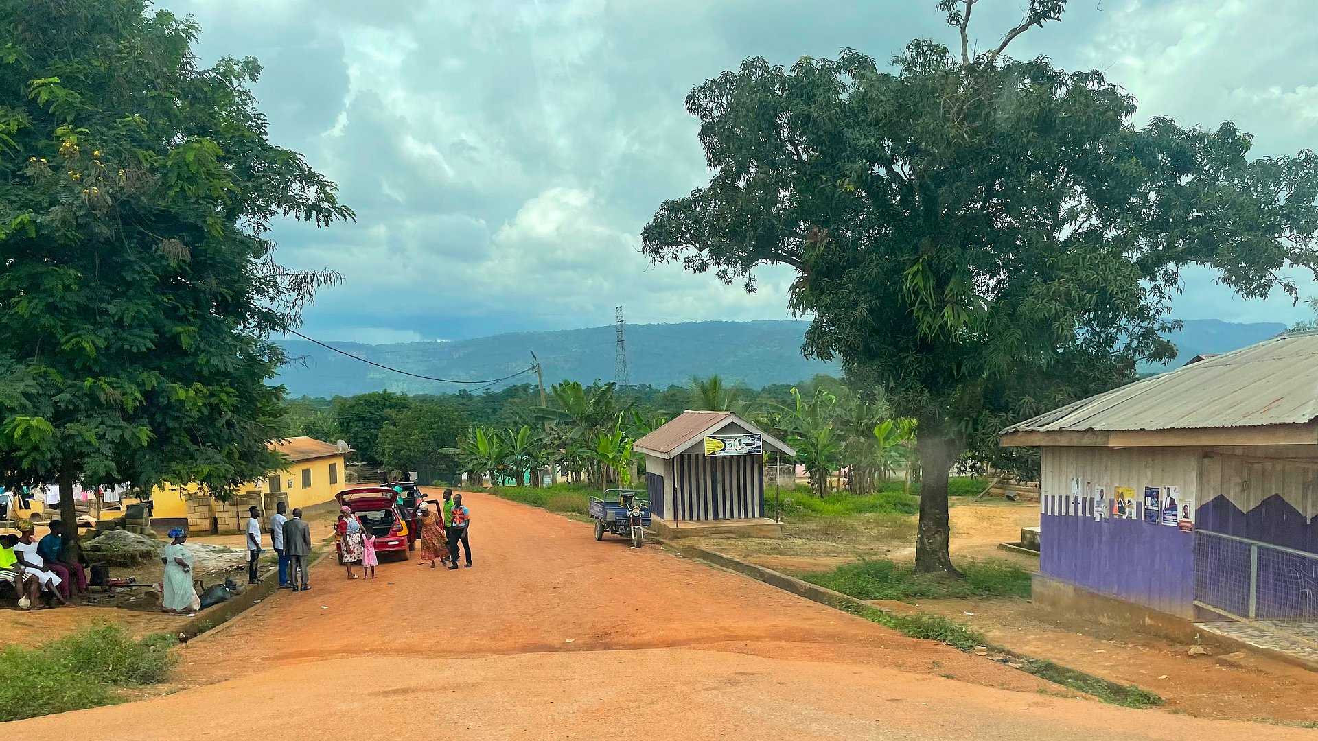 A rural road in Ghana with houses and people A rural road in Ghana with houses and people
